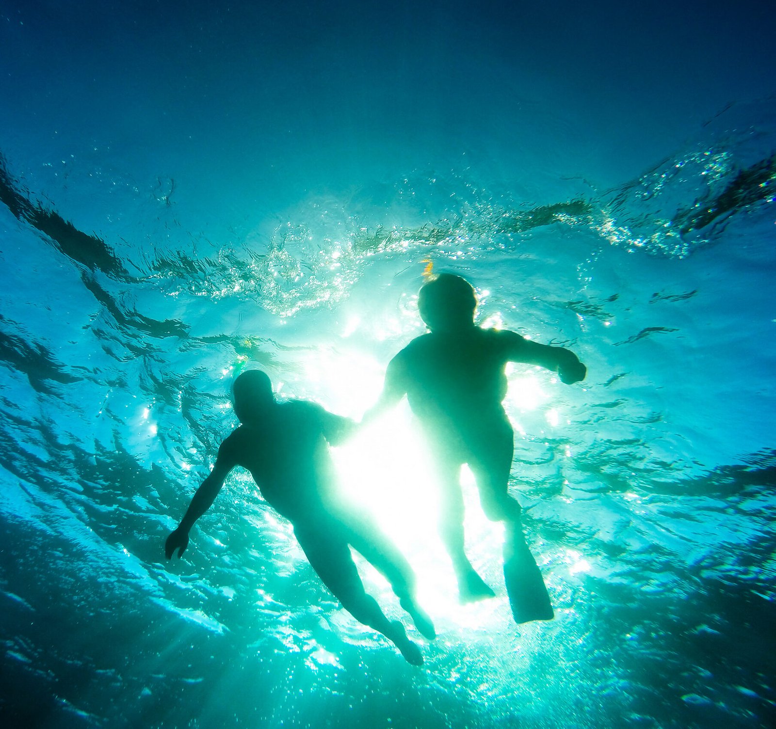 Silhouette of senior couple swimming together in tropical sea - Snorkeling tour in exotic scenarios - Concept of active elderly and fun around the world - Soft focus due to backlight and water density