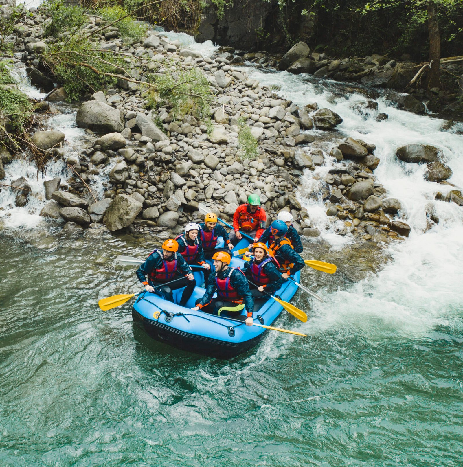 Group of people rafting in rubber dinghy on a river